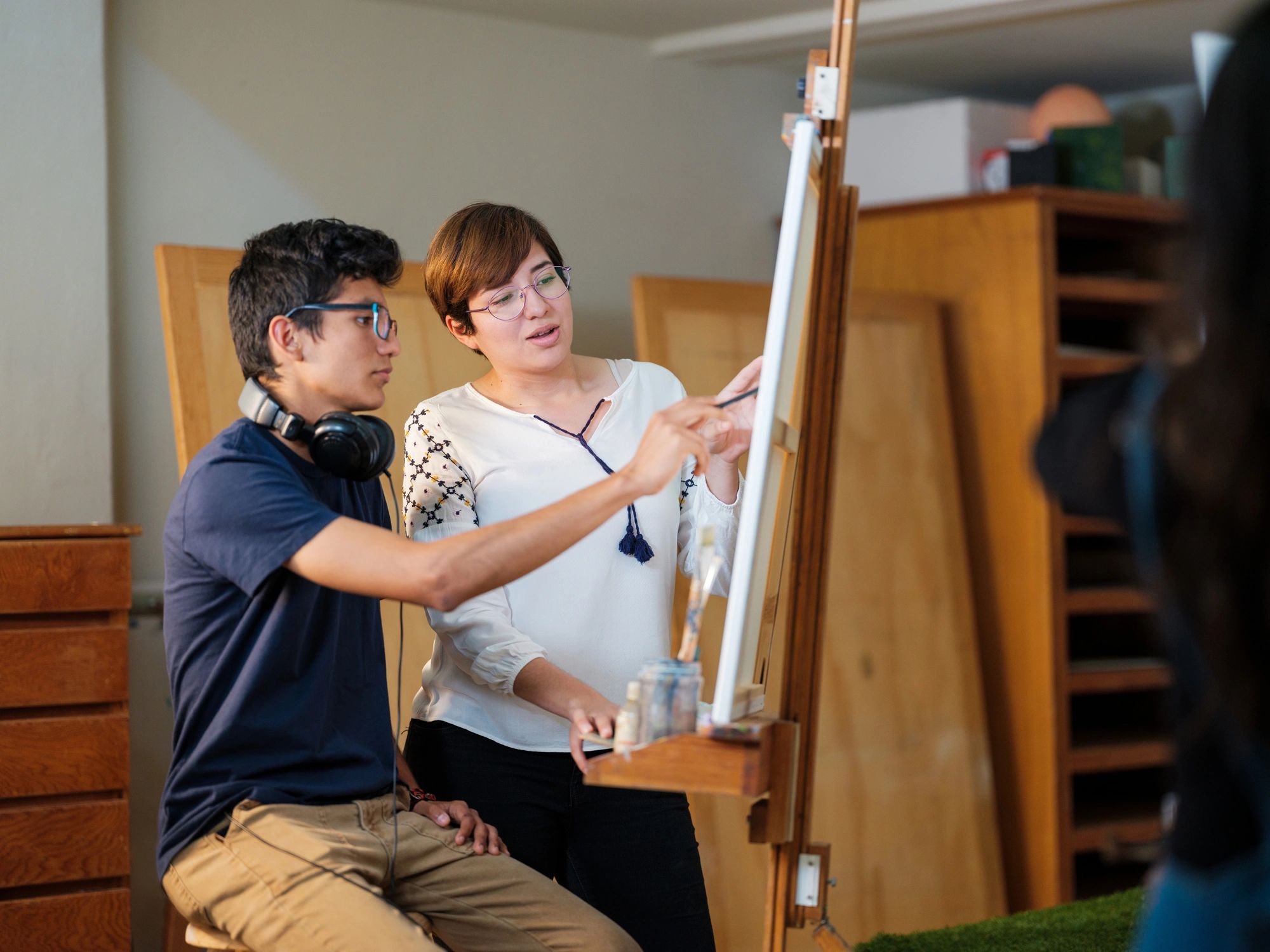 Teacher guiding a student during a creative lesson