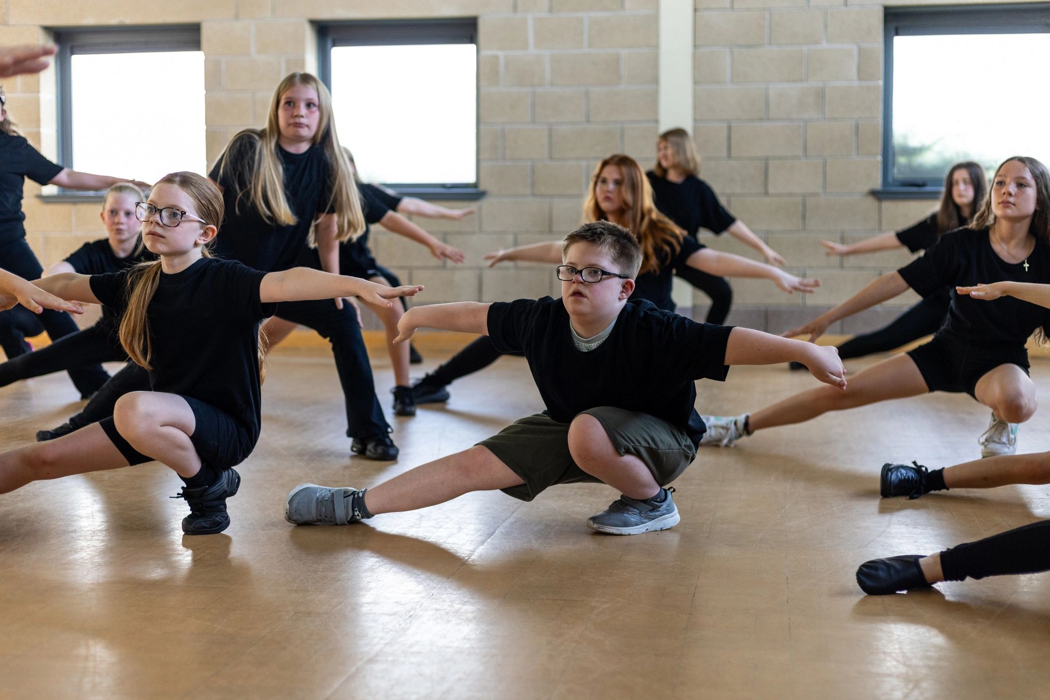 Young performers warming up together in a rehearsal space